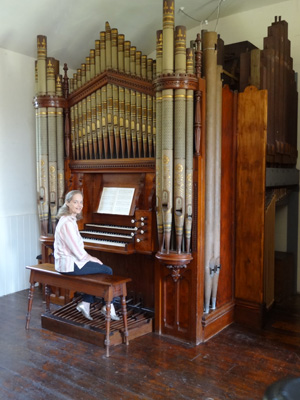 Photograph of Margaret seated at an organ.